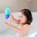 Child watching Squeezi Shark float and squirt water during bath time
