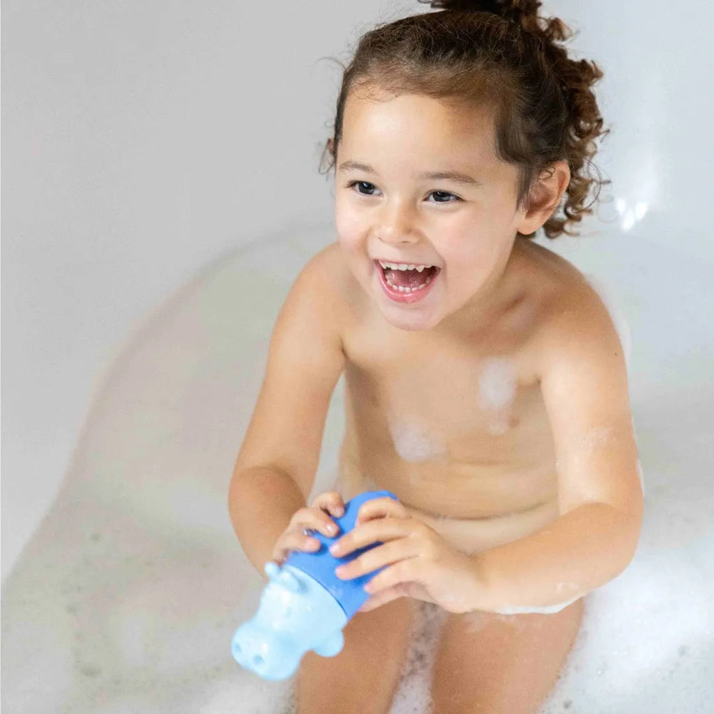 Child filling Squeezi Hippo with water during bath time