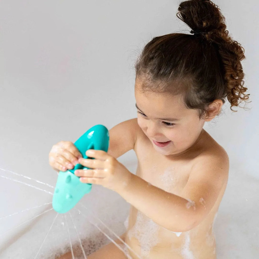 Toddler enjoying imaginative water play with Squeezi Croco