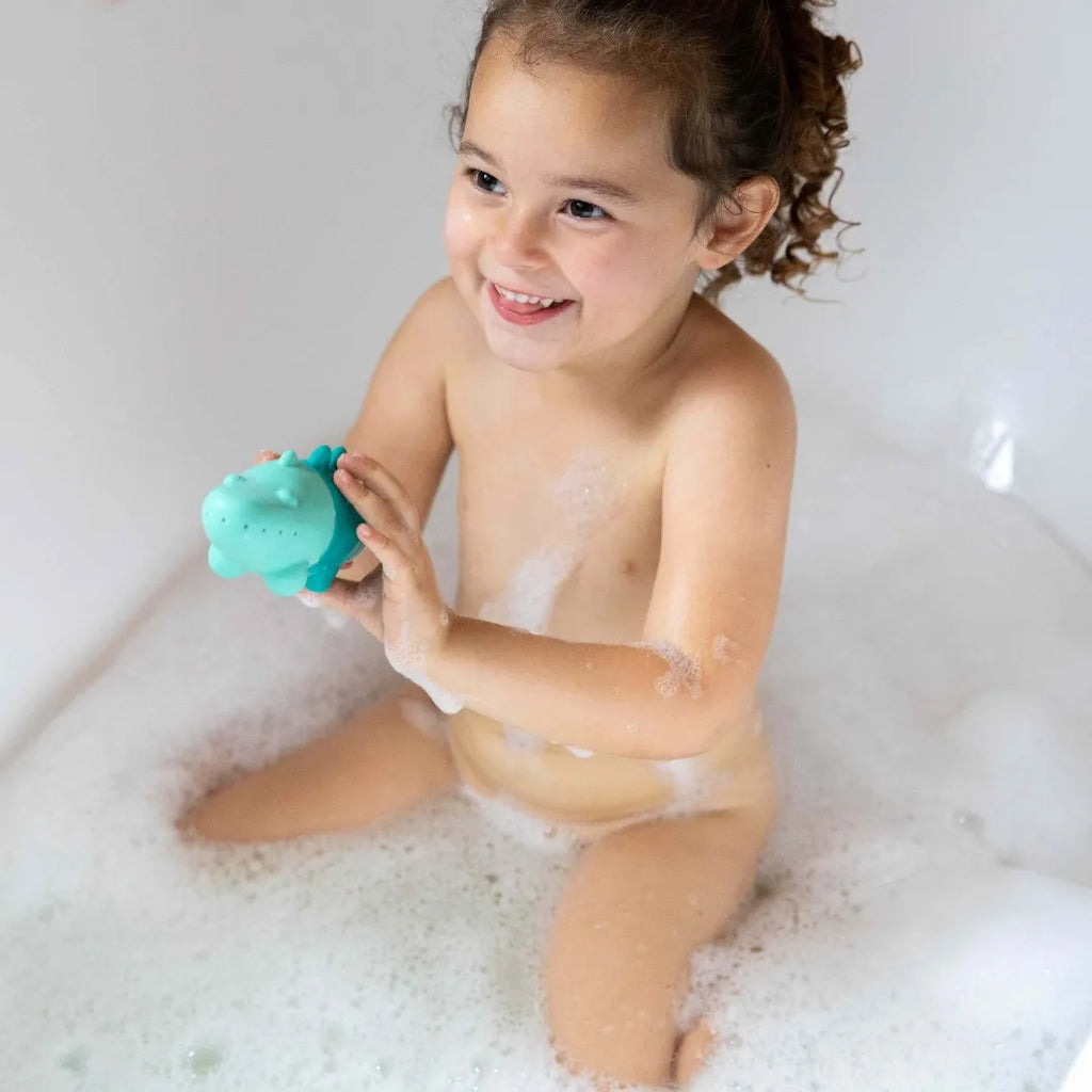 Toddler squeezing Squeezi Croco during bath time water play