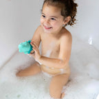 Toddler squeezing Squeezi Croco during bath time water play
