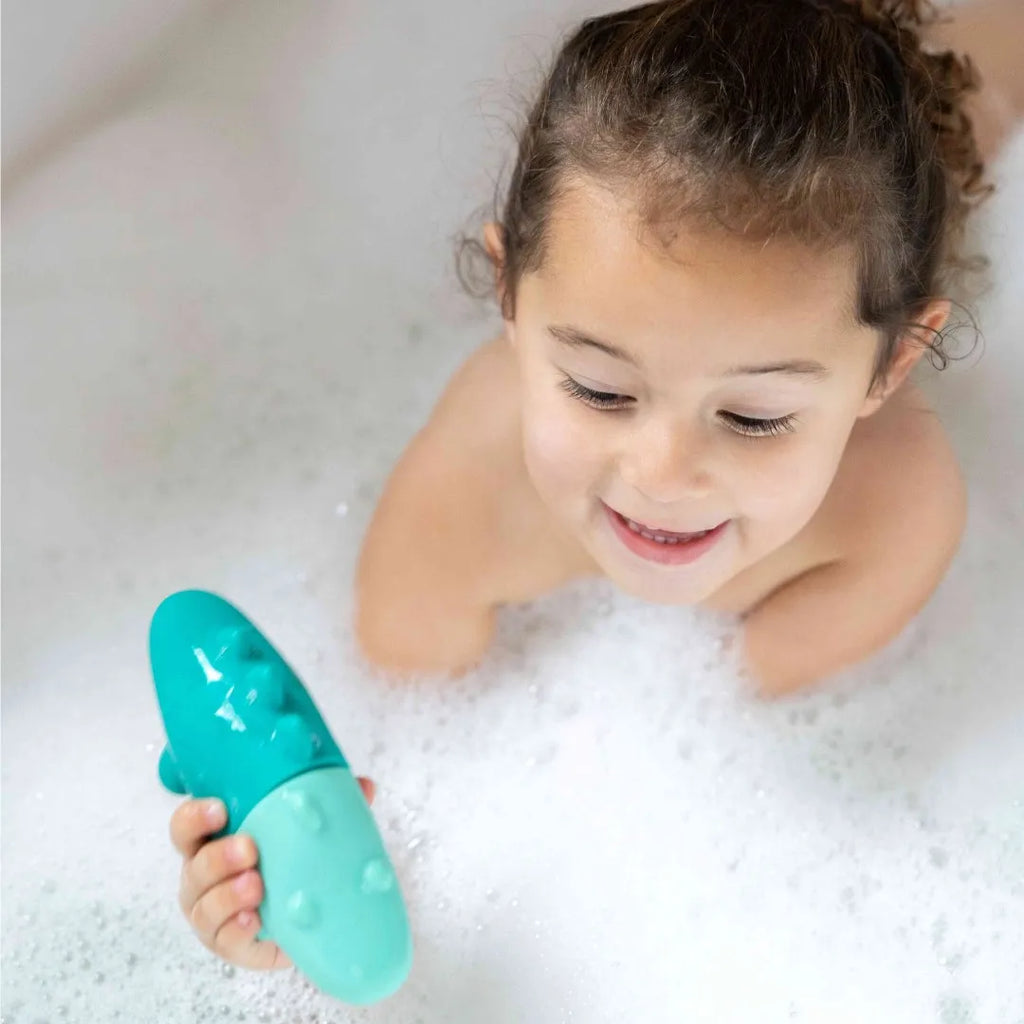 Child filling and floating Squeezi Croco in the bathtub