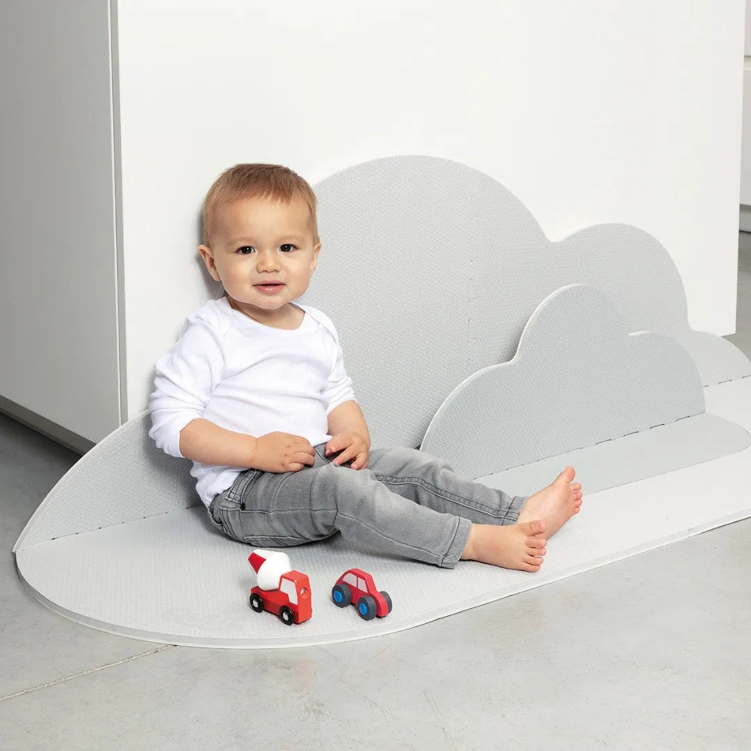 Toddler playing with toys on Clouds waterproof playmat