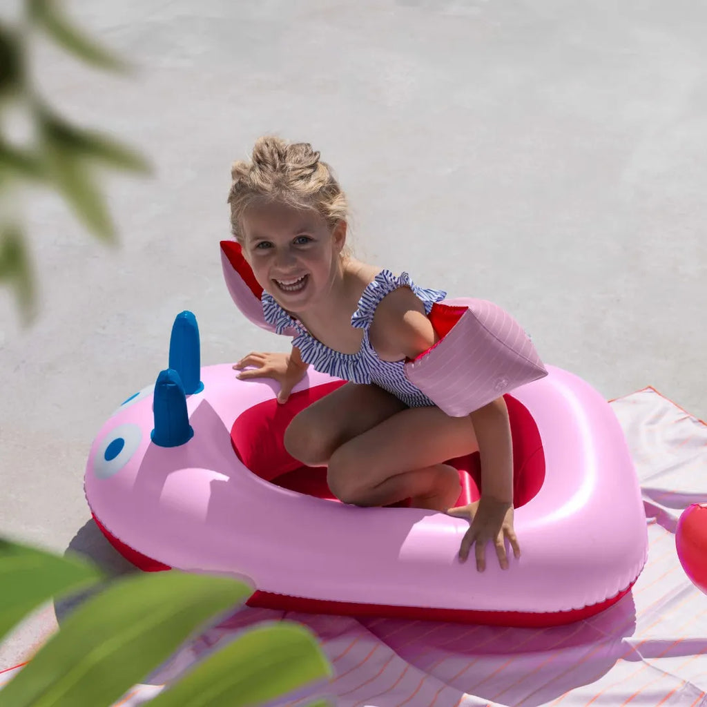 Child pretending to sail in a playful inflatable boat toy