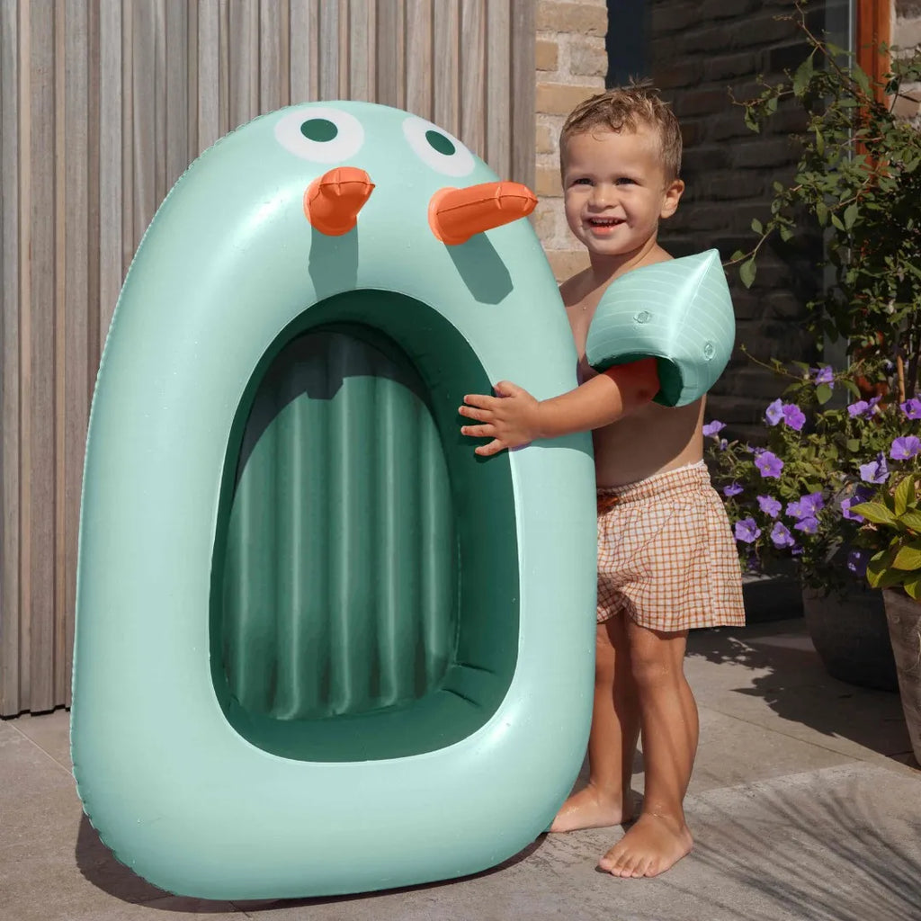 Kids splashing and playing together with an inflatable pool boat