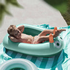 Young child using an inflatable boat during bath time fun