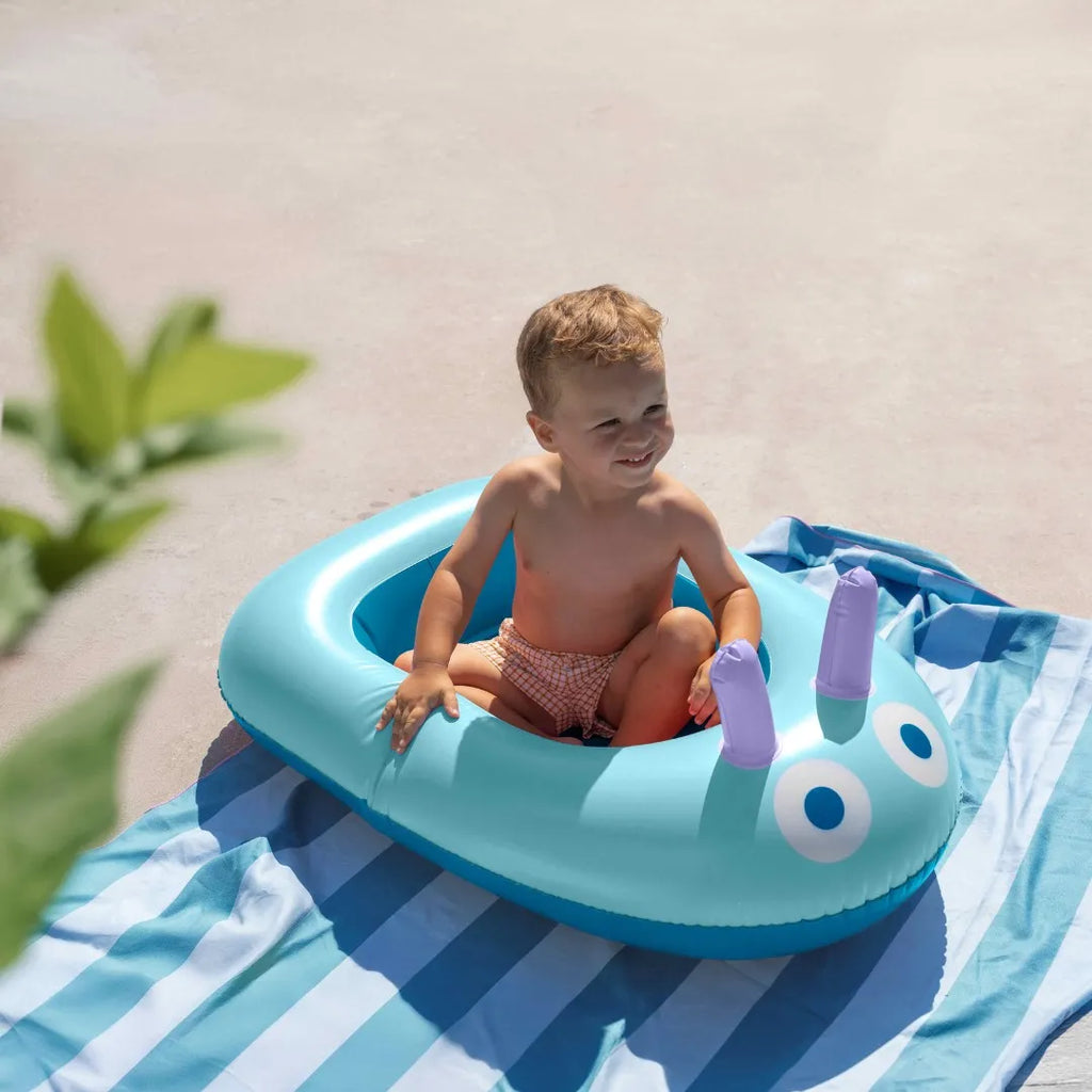 Child enjoying supervised pool play in a colorful inflatable boat