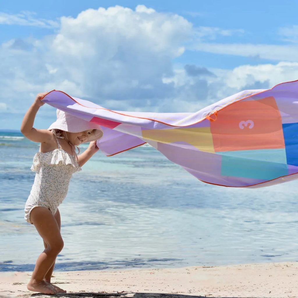 Kids jumping and playing hopscotch on a colorful beach play towel