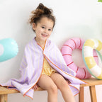 Children enjoying active outdoor play on a hopscotch towel by the pool