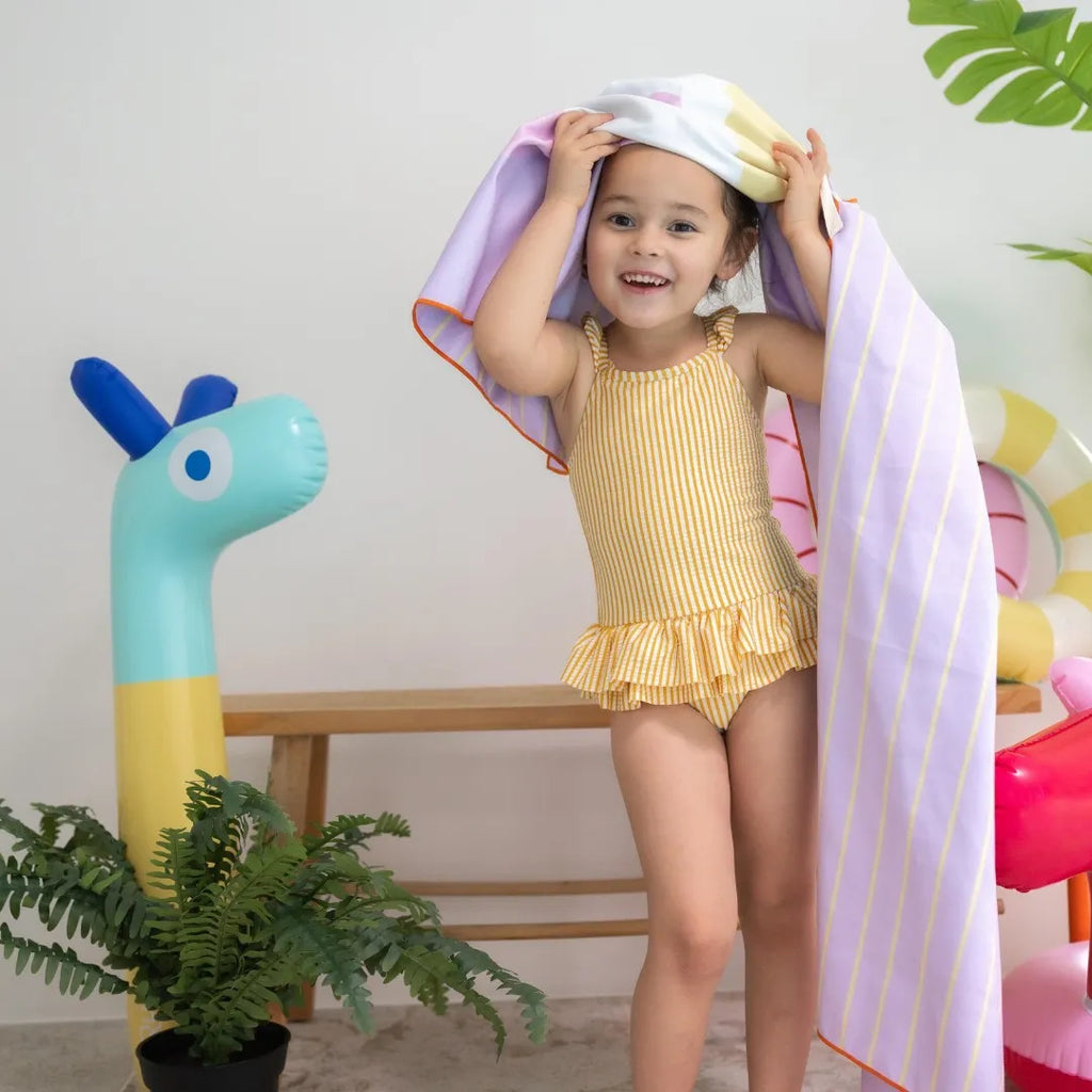 Kids laughing while playing hopscotch on a lightweight outdoor towel
