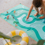 Kids playing on safari-themed double-sided play towel outdoors