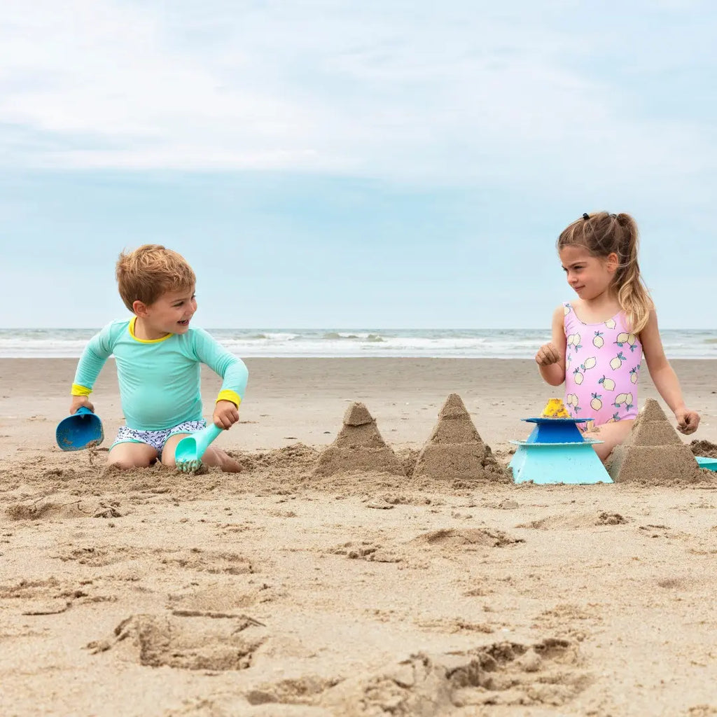 Toddler digging sand with Raki 2-in-1 Rake & Shovel at the beach
