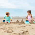 Toddler digging sand with Raki 2-in-1 Rake & Shovel at the beach