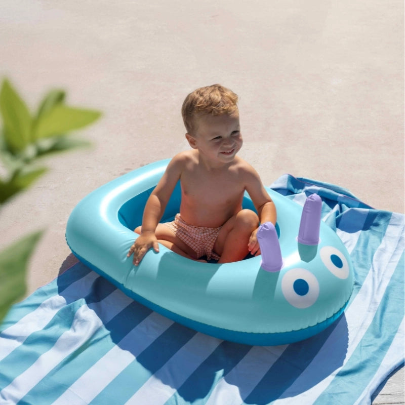 Children enjoying imaginative and active water play with a colorful inflatable boat