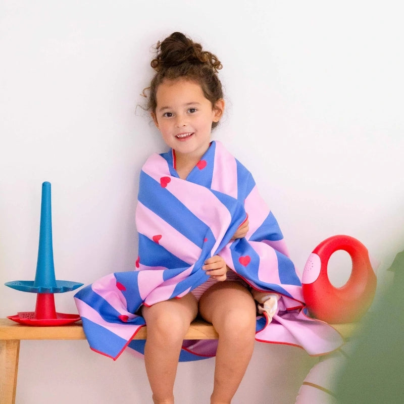 Kids playing and relaxing with a lighthouse-themed double-sided towel outdoors