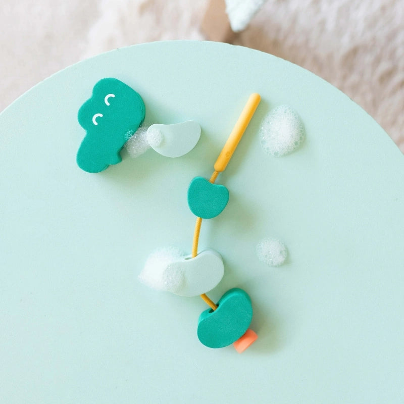 Beedi Croco in action with toddlers lacing, floating, and stacking foam beads during bath time