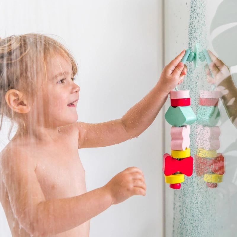 Beedi Shapes in action with toddlers floating, sticking, and lacing foam beads during bath play