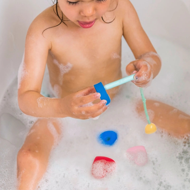 Beedi Hearts in action with toddlers floating, sticking, and lacing foam beads during bath play