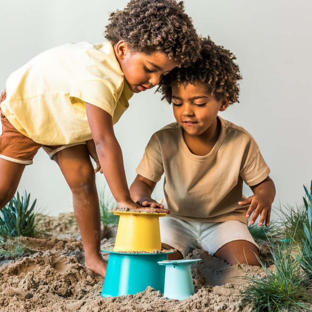 Child building multi-layered sand towers with Alto Sandcastle Builder