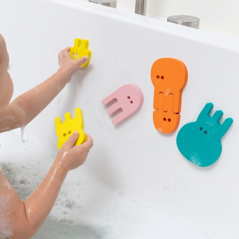 Toddler playing with Bath Puzzle Jellyfish floating foam shapes during bath time