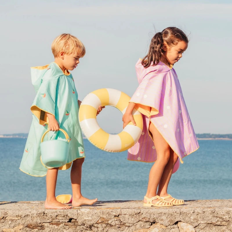 Watch kids stay warm and cozy after swimming with the Quut Beach Poncho! Quick-drying, sand-repellent microfiber keeps them comfortable, while vibrant colors make beach and pool days extra fun.