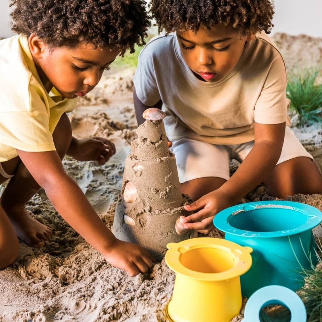 Kids creating sand villages using Alto’s small, medium, and large stackable pieces