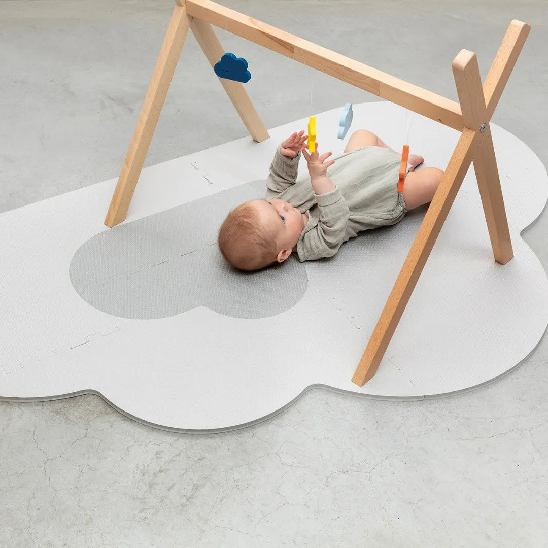 Baby relaxing on soft foam playmat in a cozy play area