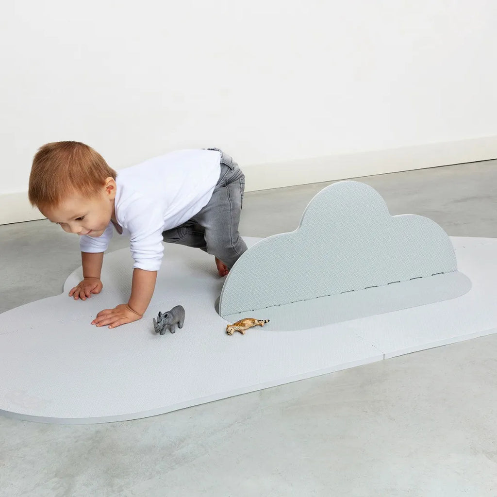 Baby rolling and exploring on cushioned playmat surface