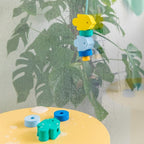 Child playing with floating Beedi Fish lacing beads in the bathtub