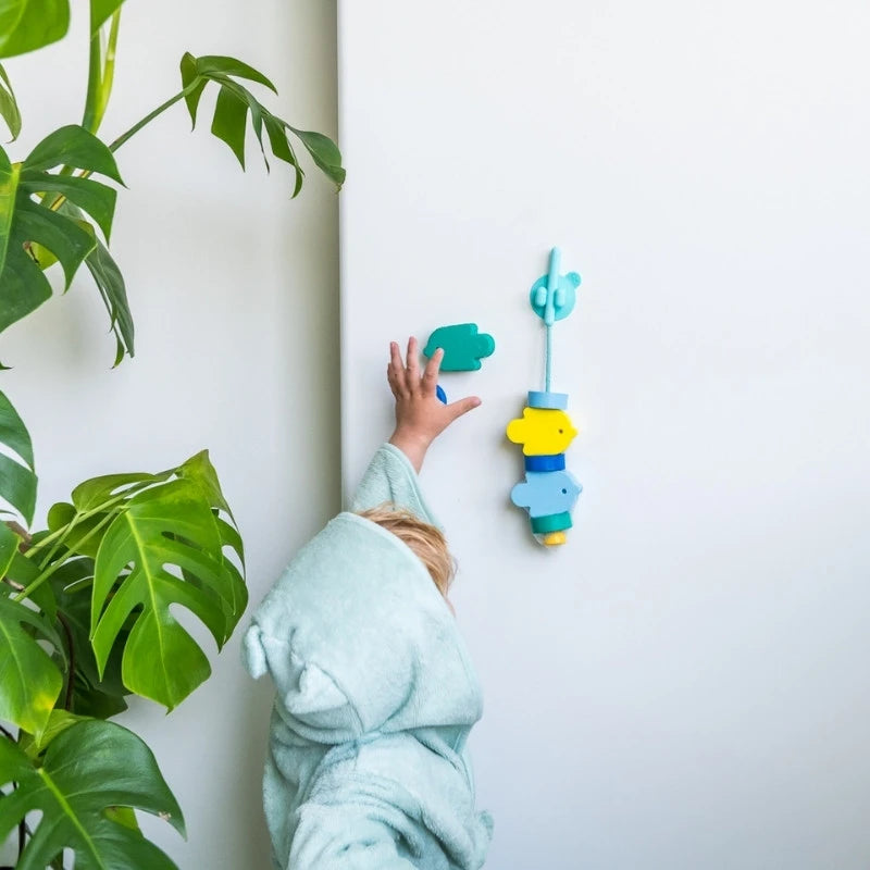 Kids sticking Beedi Fish beads to bathroom wall for creative play