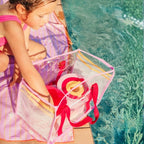 Child filling Bucki bucket with sand at the beach