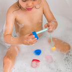 Toddler playing with Beedi Hearts floating foam beads during bath time