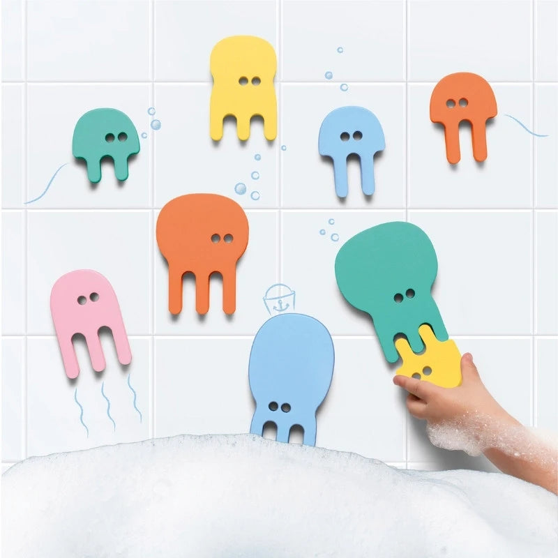 Toddler playing with floating jellyfish foam puzzle pieces in the bath