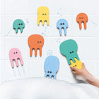 Toddler playing with floating jellyfish foam puzzle pieces in the bath