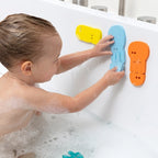 Child sticking jellyfish bath puzzle shapes to the tub wall
