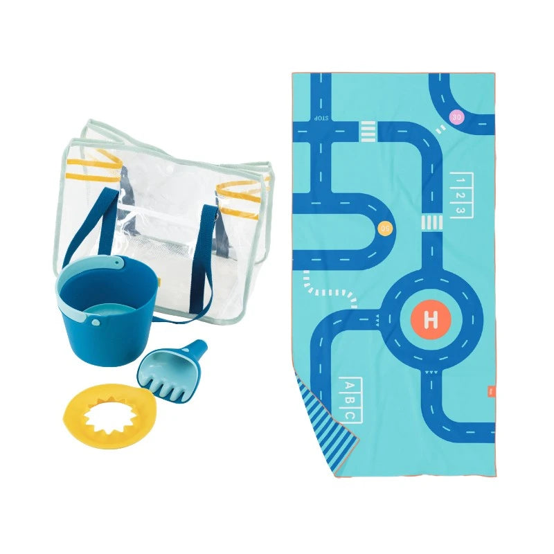 Children's playset with clear bag, blue bucket, yellow shovel, and towel with road map design on a white background.