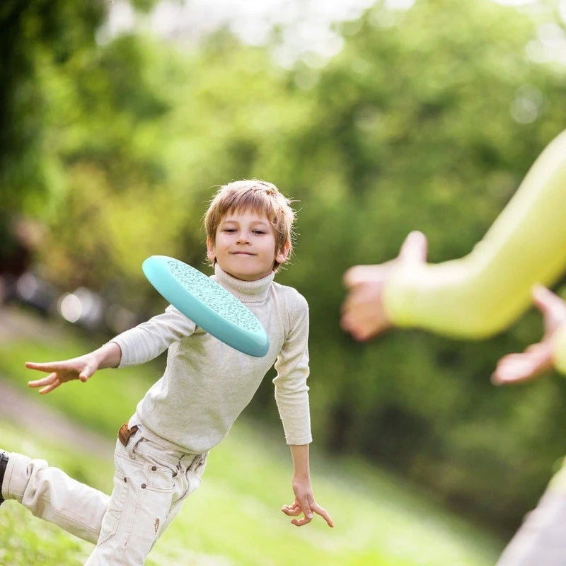 Child catching the flying disc in the garden