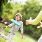 Child catching the flying disc in the garden