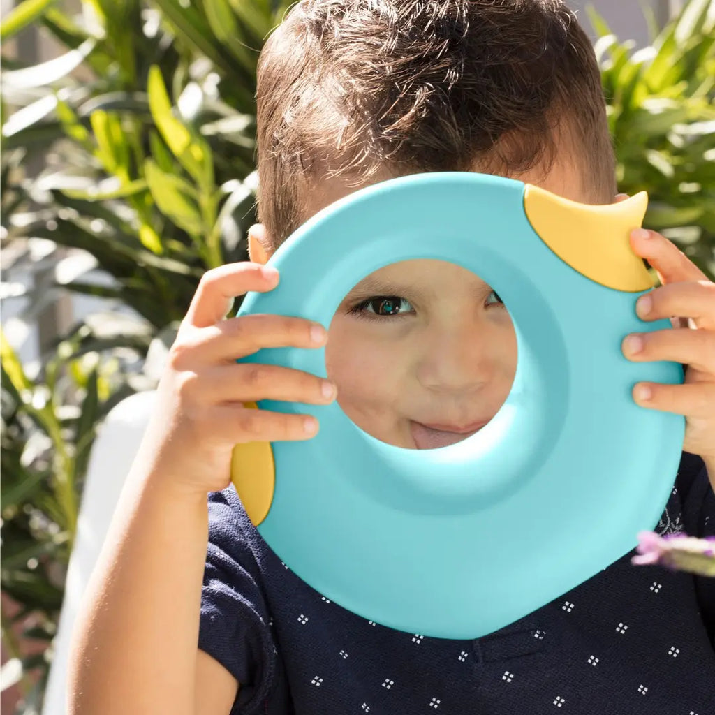 Child spraying water with banana blue Cana Watering Can at the garden
