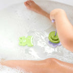 Child sticking foam frogs and water lilies on tub wall