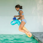 Child using Noodle Giraffe as a water noodle for pool play