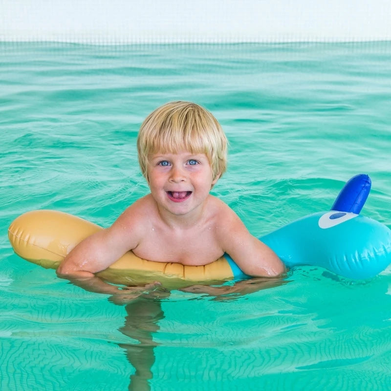 Child floating on Noodle Giraffe in pool water
