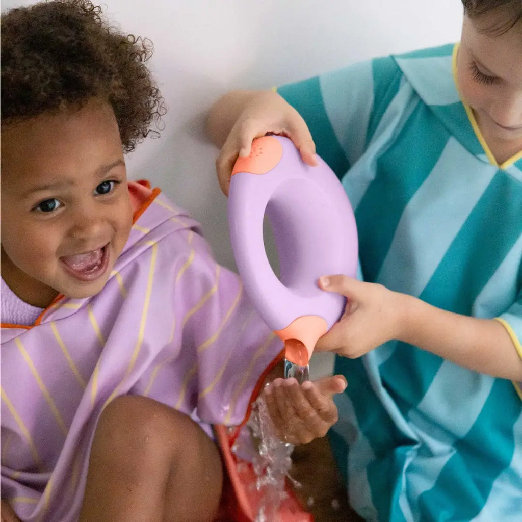Toddler holding Cana Watering Can while playing at the beach