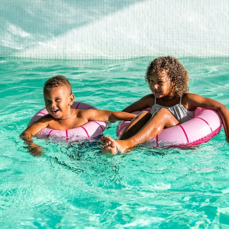 Child enjoying green Swimring in shallow pool