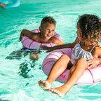 Kids laughing while splashing in colorful Swimring