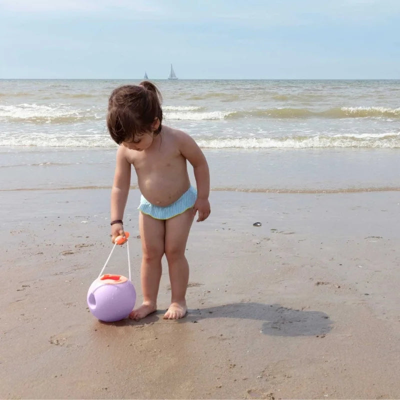 Two kids playing together with Mini Ballo no-spill buckets in the sand