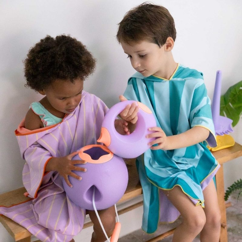 Child practicing water flow control using a Cana bath watering can