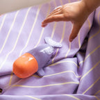 Child reaching a Squeezi Whale bath toy