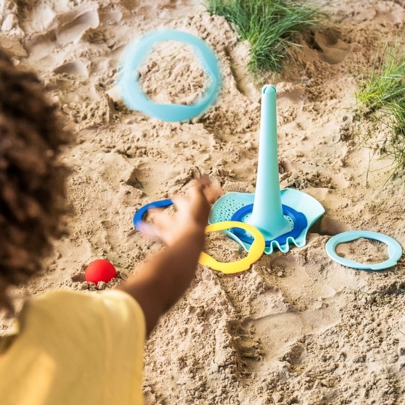 Toddler playing with Triplet to create sand shapes