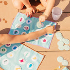 Child matching colors on a travel Bingo card during a car ride